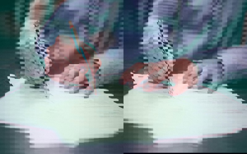 Close up photo of a person signing a document