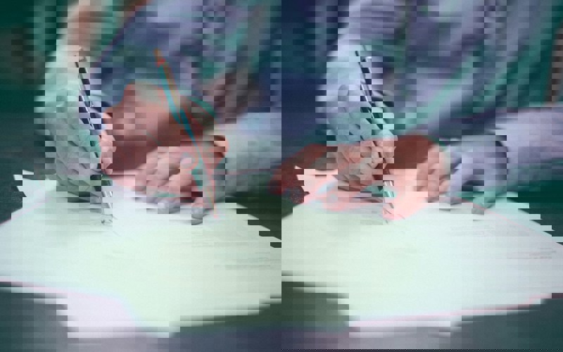 Close up photo of a person signing a document