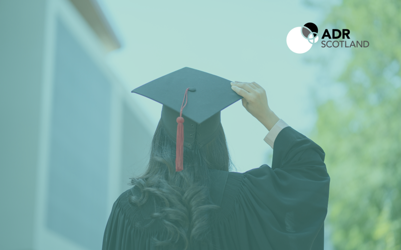 Person with long dark hair and their back towards the camera wears a graduate cap and gown. ADR Scotland logo displayed as this dataset is ADR Scotland.
