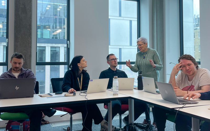 Synthetic data workshop, Professor Gillian Raab is standing, speaking to a seated group of people with laptops