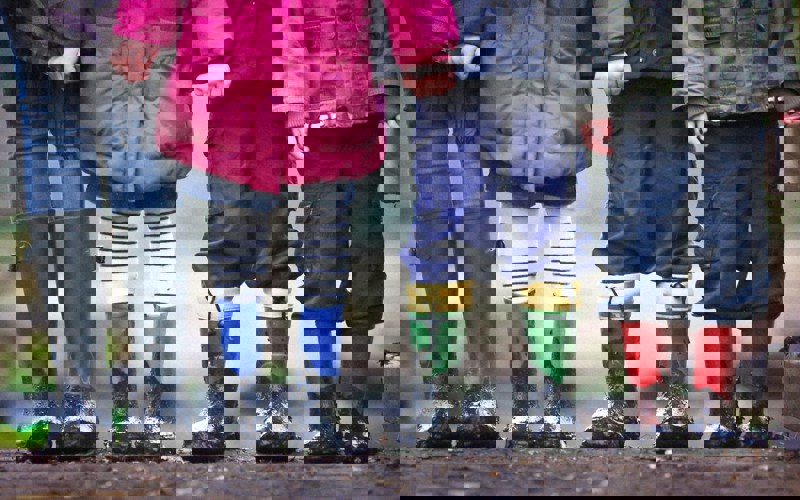 Four children wearing muddy boots